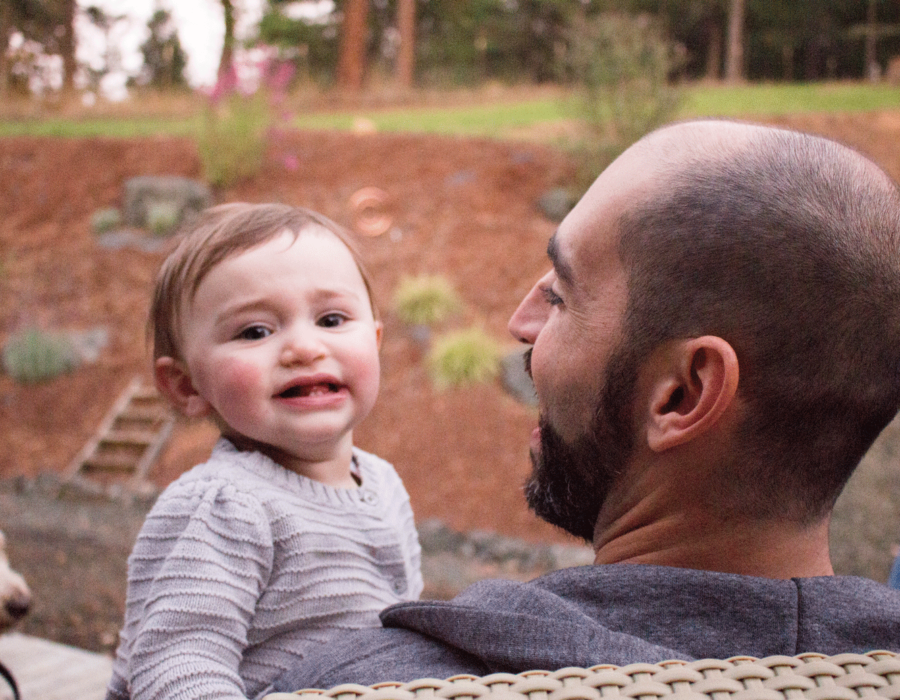 family-photography-daddy-holding-baby-dog-in-background