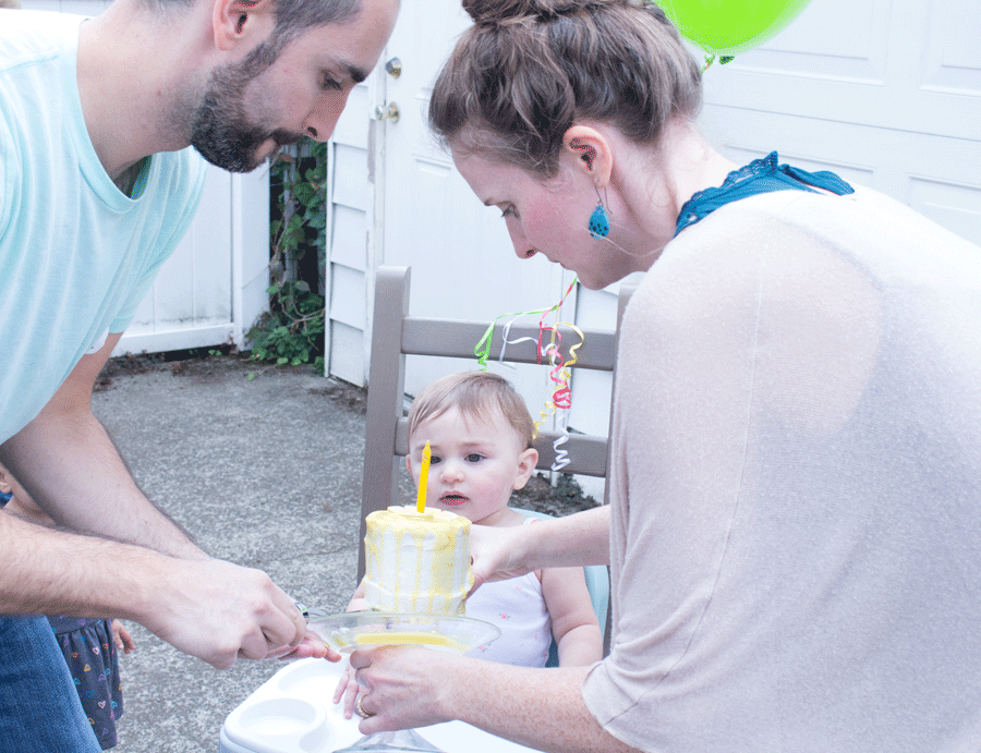 first-birthday-parents-serving-baby-yellow-and-white-cake